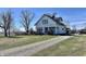 Inviting two-story white farmhouse with gravel driveway, and traditional architecture, on a sunny day at 810 S 400 W, Bargersville, IN 46106