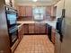 Functional kitchen with wooden cabinets, black oven, and tile floor at 810 S 400 W, Bargersville, IN 46106