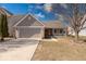 Charming home featuring brick and siding exterior, two-car garage, and cozy front porch at 8318 Golden Ridge Ln, Indianapolis, IN 46237