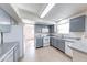 An open kitchen featuring grey cabinets, laminate countertops, and a white refrigerator and range at 8517 Sweet Birch Dr, Indianapolis, IN 46239