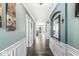 Hallway with wood floors, mirrors, and decorative wainscoting at 8759 Buttonbush Cir, Plainfield, IN 46168