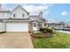 Charming townhome with a brick facade, attached garage, and well-maintained front lawn with garden beds at 915 Prestwick Dr # D, Indianapolis, IN 46214