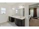 Bathroom vanity featuring double sinks, a large mirror, dark cabinets, and tiled flooring at 10890 Poppy Hill Dr, Indianapolis, IN 46234