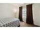 Cozy bedroom features a window with decorative curtains and a plaid bedspread at 10890 Poppy Hill Dr, Indianapolis, IN 46234