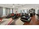 Spacious living room with a modern black sectional sofa, decorative rug, and open layout to the kitchen at 10890 Poppy Hill Dr, Indianapolis, IN 46234