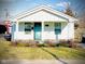 Charming one-story home with a tidy yard, front porch and an inviting turquoise-colored front door at 1133 S Kealing Ave, Indianapolis, IN 46203