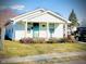 Charming one-story home with a tidy yard, front porch and an inviting turquoise-colored front door at 1133 S Kealing Ave, Indianapolis, IN 46203