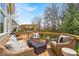 Inviting back deck with wicker furniture, fire pit, and pergola with beautiful backyard views at 11367 Zanardi Ct, Zionsville, IN 46077