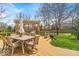 Spacious back deck with a dining table, a pergola, and lush landscaping at 11367 Zanardi Ct, Zionsville, IN 46077