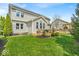 View of home's rear exterior, showcasing the deck, lawn, solar panels, and manicured landscaping at 11367 Zanardi Ct, Zionsville, IN 46077