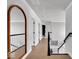 Bright hallway with wood floors, white trim, and a large mirror reflecting the stairs at 11367 Zanardi Ct, Zionsville, IN 46077