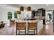 Open-concept kitchen with granite counters and wicker barstools at 11367 Zanardi Ct, Zionsville, IN 46077