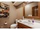 Neutral half bathroom with oak trimmed mirror, decorative accents, and single sink vanity at 11691 Diamond Pointe Ct, Indianapolis, IN 46236