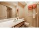 Neutral bathroom with striped wallpaper, white countertop sink, and shower with glass doors at 11691 Diamond Pointe Ct, Indianapolis, IN 46236