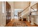 Inviting foyer showcasing hardwood floors, a staircase with white railings, and views into the formal dining room at 11691 Diamond Pointe Ct, Indianapolis, IN 46236