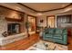 Cozy living room featuring a brick fireplace, hardwood floors and a green sofa at 11691 Diamond Pointe Ct, Indianapolis, IN 46236