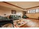 Spacious living room with a green leather sofa, wood floors, and a stylish modern area rug at 11691 Diamond Pointe Ct, Indianapolis, IN 46236