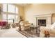 Bright living room with a cozy fireplace, large windows, and comfortable seating arrangement, perfect for relaxation at 11691 Diamond Pointe Ct, Indianapolis, IN 46236