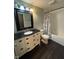 Updated bathroom features a vanity with black countertop and shower with decorative curtain at 1258 Soaring Eagle Dr, Greenwood, IN 46143