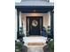 Charming front door with a black and white brick design with decorative wreath and potted plants at 1258 Soaring Eagle Dr, Greenwood, IN 46143
