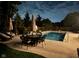 Backyard pool and patio with tables, chairs, and umbrellas at dusk at 1258 Soaring Eagle Dr, Greenwood, IN 46143