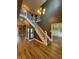 Gray and white staircase and modern chandelier in open concept home with luxury vinyl plank flooring at 1258 Soaring Eagle Dr, Greenwood, IN 46143