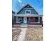 Charming blue two-story home featuring a covered front porch with brick columns at 1534 S State Ave, Indianapolis, IN 46203