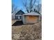View of backyard with two-story home and detached garage in need of repair at 1534 S State Ave, Indianapolis, IN 46203