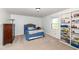 This bedroom features neutral carpeting, a built-in shelving unit, and a large window for natural light at 1728 Timber Heights Dr, Carmel, IN 46280