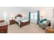 Bright bedroom with cozy sitting area featuring an upholstered chair and side table at 1728 Timber Heights Dr, Carmel, IN 46280