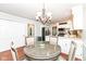 Dining room features a round table, wood floors, view of kitchen and modern chandelier at 1728 Timber Heights Dr, Carmel, IN 46280