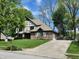 Traditional Tudor-style home featuring a brick facade, attached garage, and green front lawn at 1728 Timber Heights Dr, Carmel, IN 46280