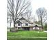 Charming Tudor-style home with brick facade, manicured lawn and a freshly paved walkway leading to the front door at 1728 Timber Heights Dr, Carmel, IN 46280