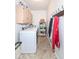 Bright laundry room features a washer, dryer, cabinets, storage shelves, and coat rack with garments at 1728 Timber Heights Dr, Carmel, IN 46280