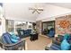 Cozy sunroom with wicker furniture, ceiling fan, brick accent wall, and sliding glass door at 1728 Timber Heights Dr, Carmel, IN 46280