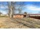 A view of the home's brick exterior and covered back porch, surrounded by a large yard at 230 N School St, Fortville, IN 46040