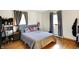 Bedroom with hardwood floors, natural light, and a gray upholstered headboard at 230 N School St, Fortville, IN 46040