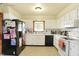 Traditional kitchen featuring white cabinets, neutral countertops, and a black refrigerator at 230 N School St, Fortville, IN 46040