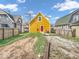 Backyard with a yellow house, gravel parking, and a small patch of grass at 251 Hendricks Pl, Indianapolis, IN 46201
