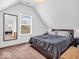 Bedroom with angled ceiling, cozy bed, and a mirror at 251 Hendricks Pl, Indianapolis, IN 46201