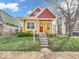 Charming yellow house with red accents, complemented by well-manicured front lawn at 251 Hendricks Pl, Indianapolis, IN 46201