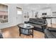 Light-filled living room with hardwood floors, staircase, and an adjacent modern kitchen at 251 Hendricks Pl, Indianapolis, IN 46201