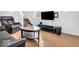 Comfortable living room featuring hardwood floors, TV, and adjacent staircase at 251 Hendricks Pl, Indianapolis, IN 46201