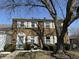 Charming townhouse featuring a brick facade, white shutters, and mature landscaping at 2826 Country Estates Dr, Indianapolis, IN 46227