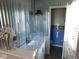 This remodeled bathroom features silver corrugated metal walls, a white vanity, and a view of the toilet at 3300 Heritage Rd, Columbus, IN 47203