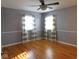 This main bedroom has light-grey walls, wood flooring, and two windows with matching curtains at 3300 Heritage Rd, Columbus, IN 47203