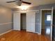This main bedroom has wood floors and a closet with white shutter doors and a modern ceiling fan at 3300 Heritage Rd, Columbus, IN 47203