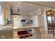 Well-lit kitchen with white cabinets, appliances, and bar, with view to living area at 3300 Heritage Rd, Columbus, IN 47203