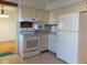 Well-lit kitchen with white appliances and neutral cabinets at 3300 Heritage Rd, Columbus, IN 47203