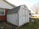 White wooden backyard shed for extra storage with gray shingled roof at 3300 Heritage Rd, Columbus, IN 47203
